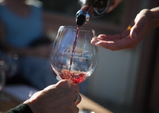 Picture shows red wine being poured into a glass.