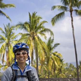 Cyclist posing for camera with coconut trees  Hawaii Bike Tour