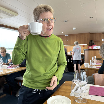 A bike rider enjoying a cup of coffee in the dining room on the Vita Pugna barge on the Italy bike and barge tour for women only.