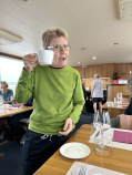 A bike rider enjoying a cup of coffee in the dining room on the Vita Pugna barge on the Italy bike and barge tour for women only.