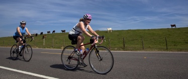 Two cyclist riding along side farm during Louisiana Bike Tour